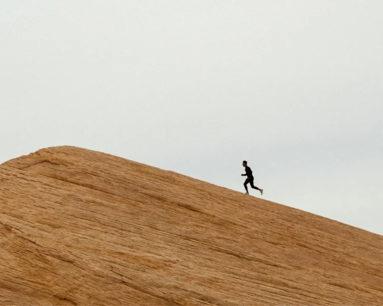 Runner silhouetted on a sand dune ridge