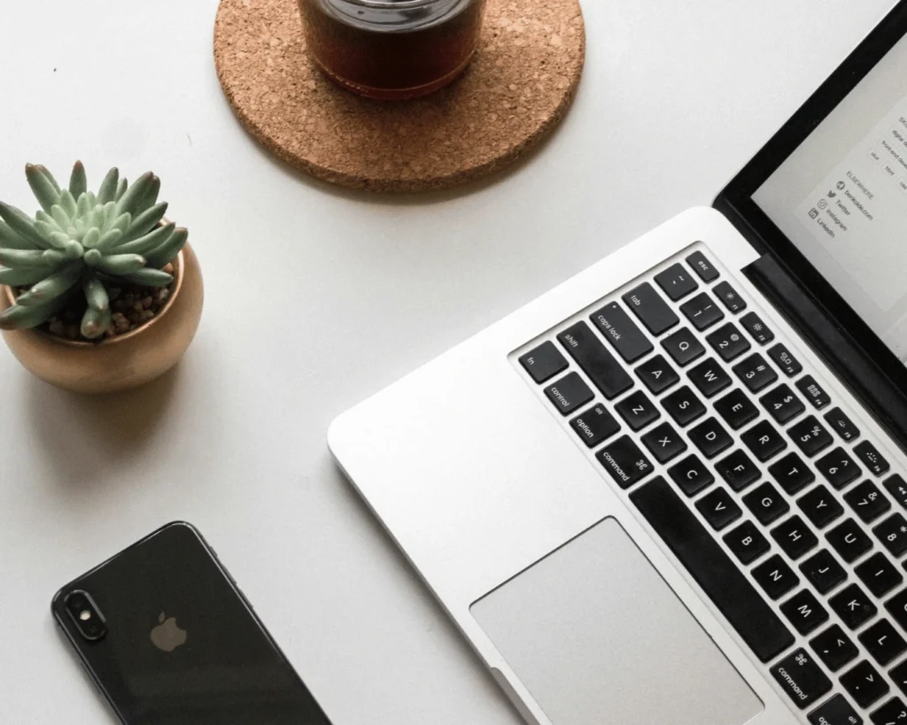 Laptop, phone and coffee on a desk, flat lay