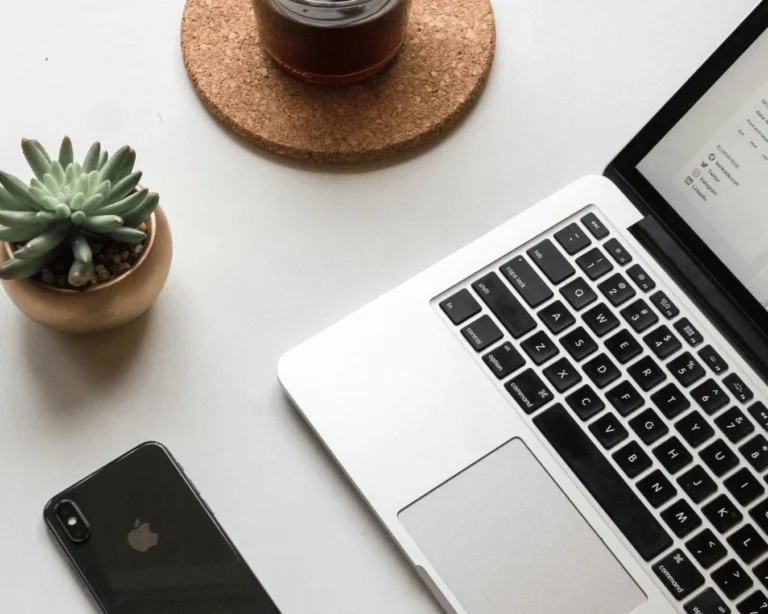 Laptop, phone and coffee on a desk, flat lay