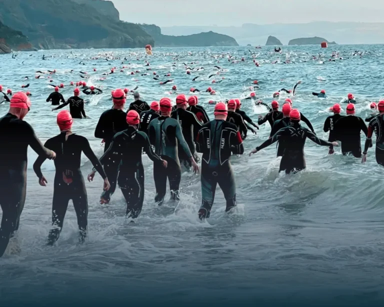 Open water swimmers entering the sea at Ironman Wales
